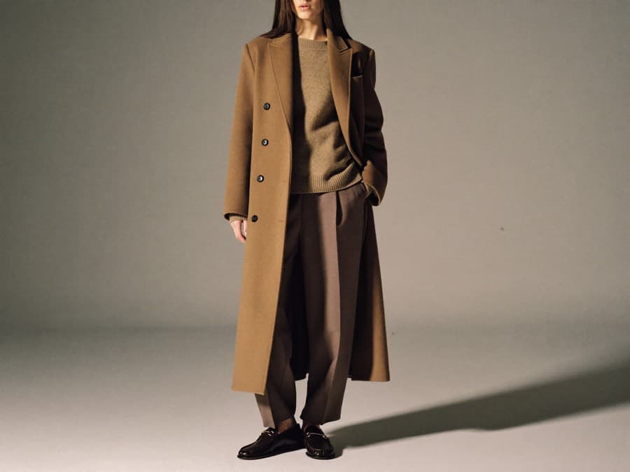 A model in a tonal winter look built around a long camel overcoat